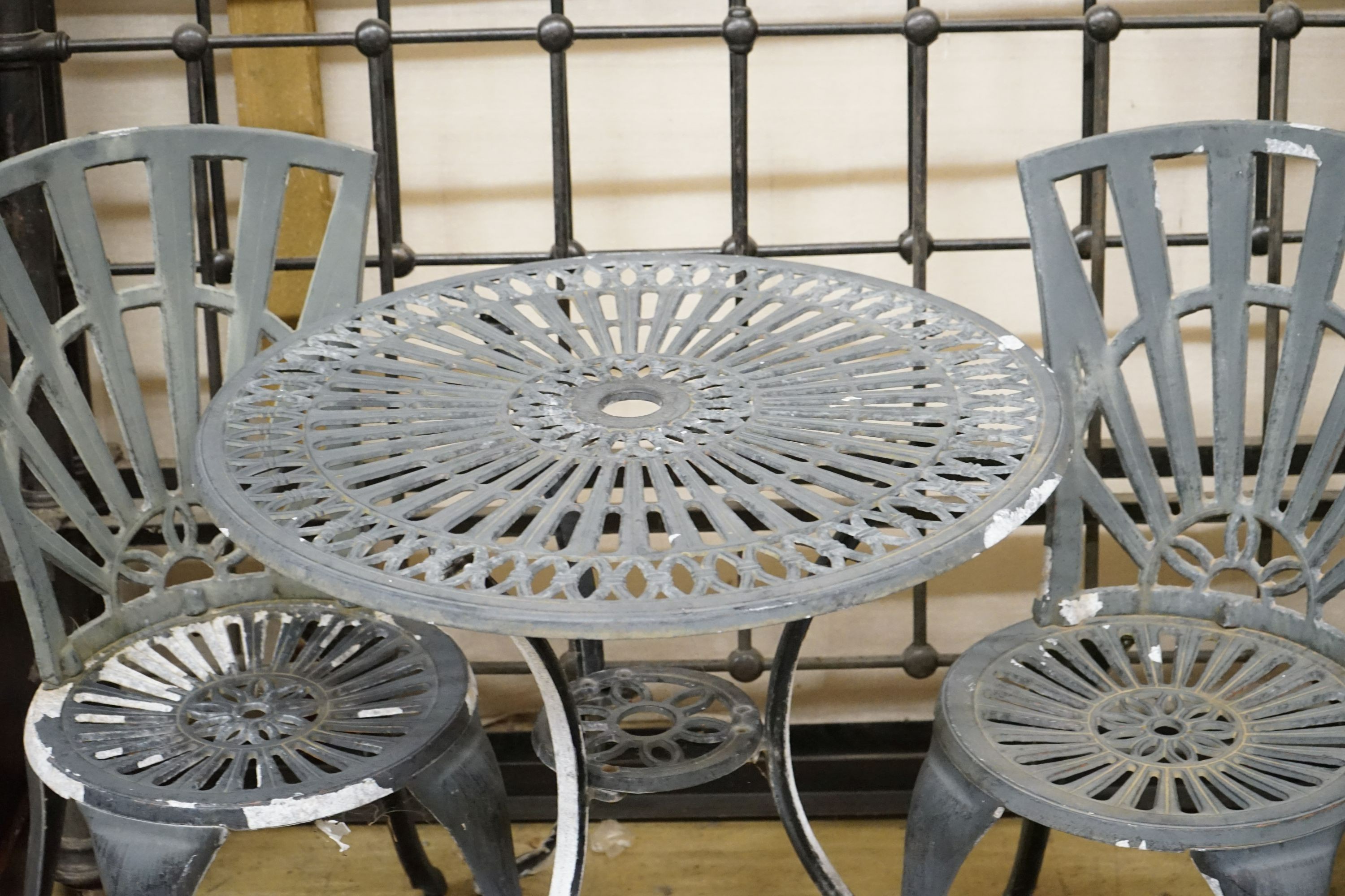 A painted aluminium circular garden table, diameter 69cm, height 66cm and two chairs